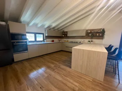 Cucina Valdesign moderna in mansarda a Riposto CT: composizione angolare con penisola e top in gres